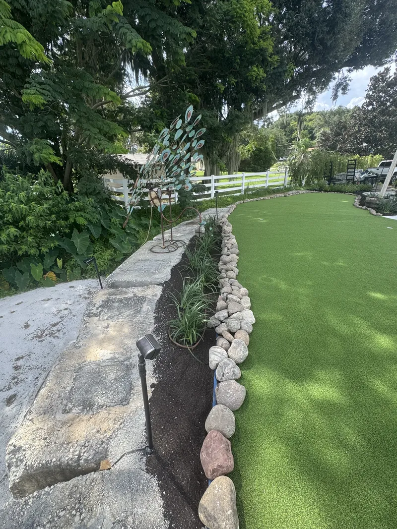 Fresh planting along the edge of a backyard putting green