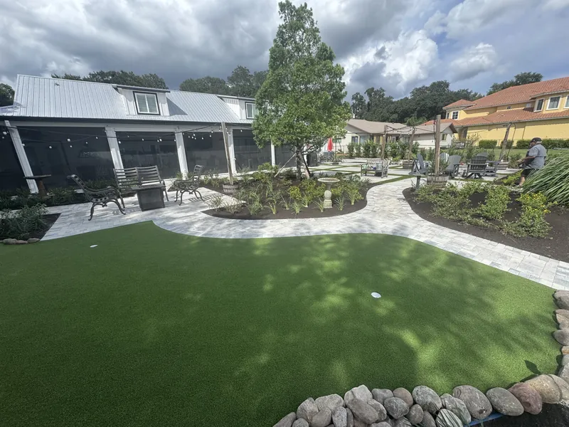 Backyard planting beds beside a patio and putting green